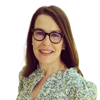 A headshot of Janell, wearing a floral blouse and glasses