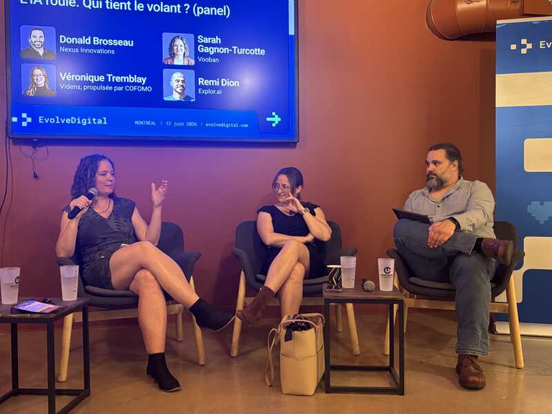  Panelists Sarah, Véronique and Donald speak on stage during the L’IA roule. Qui tient le volant? discussion, with a screen showing Donald Brosseau, Véronique Tremblay, Sarah Gagnon-Turcotte, and Rémi Dion.