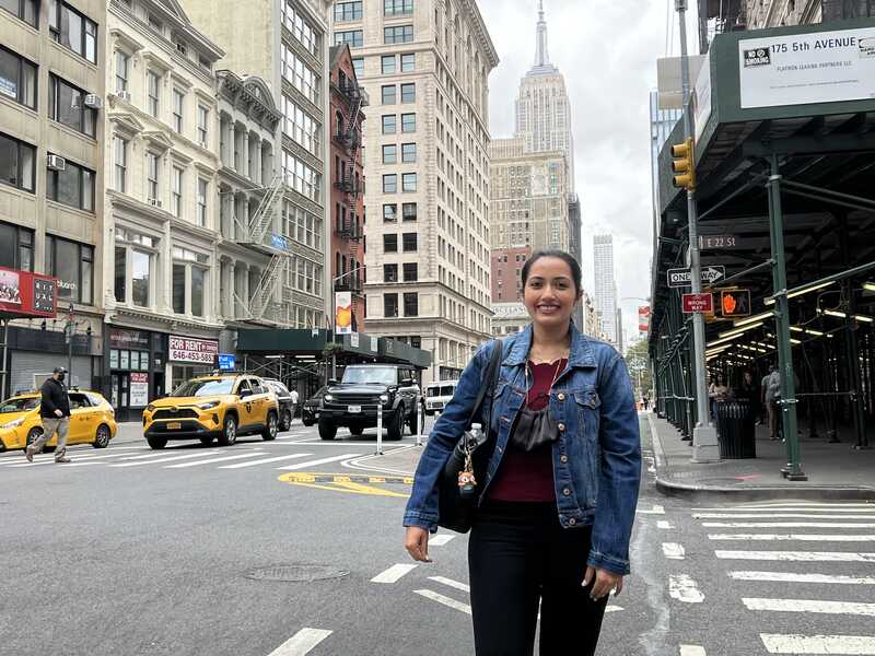Woman crossing crosswalk in busy city street