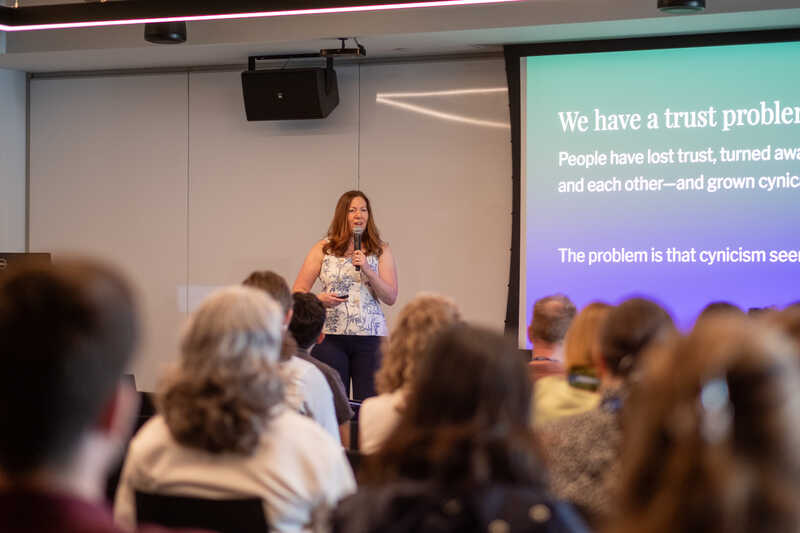 Margot standing in front a crowd presenting