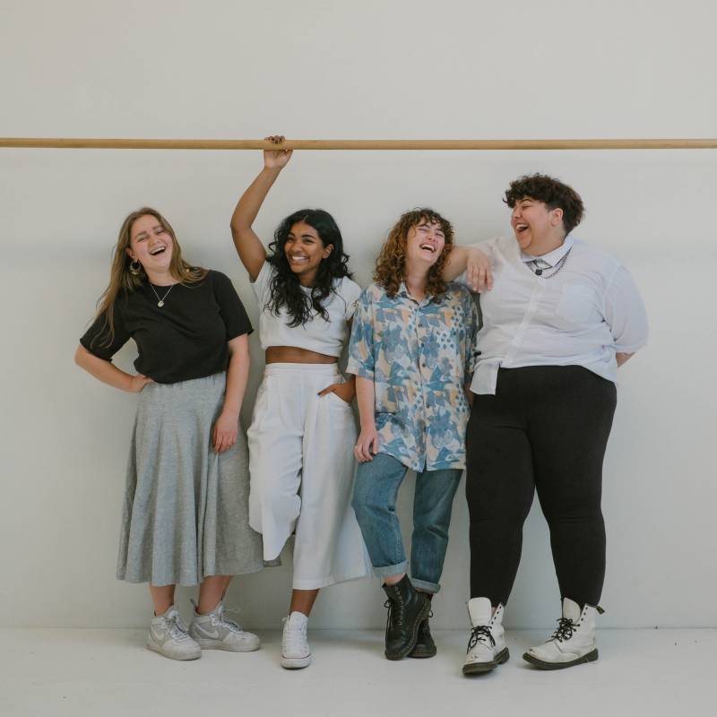 A diverse lineup of women against a white wall