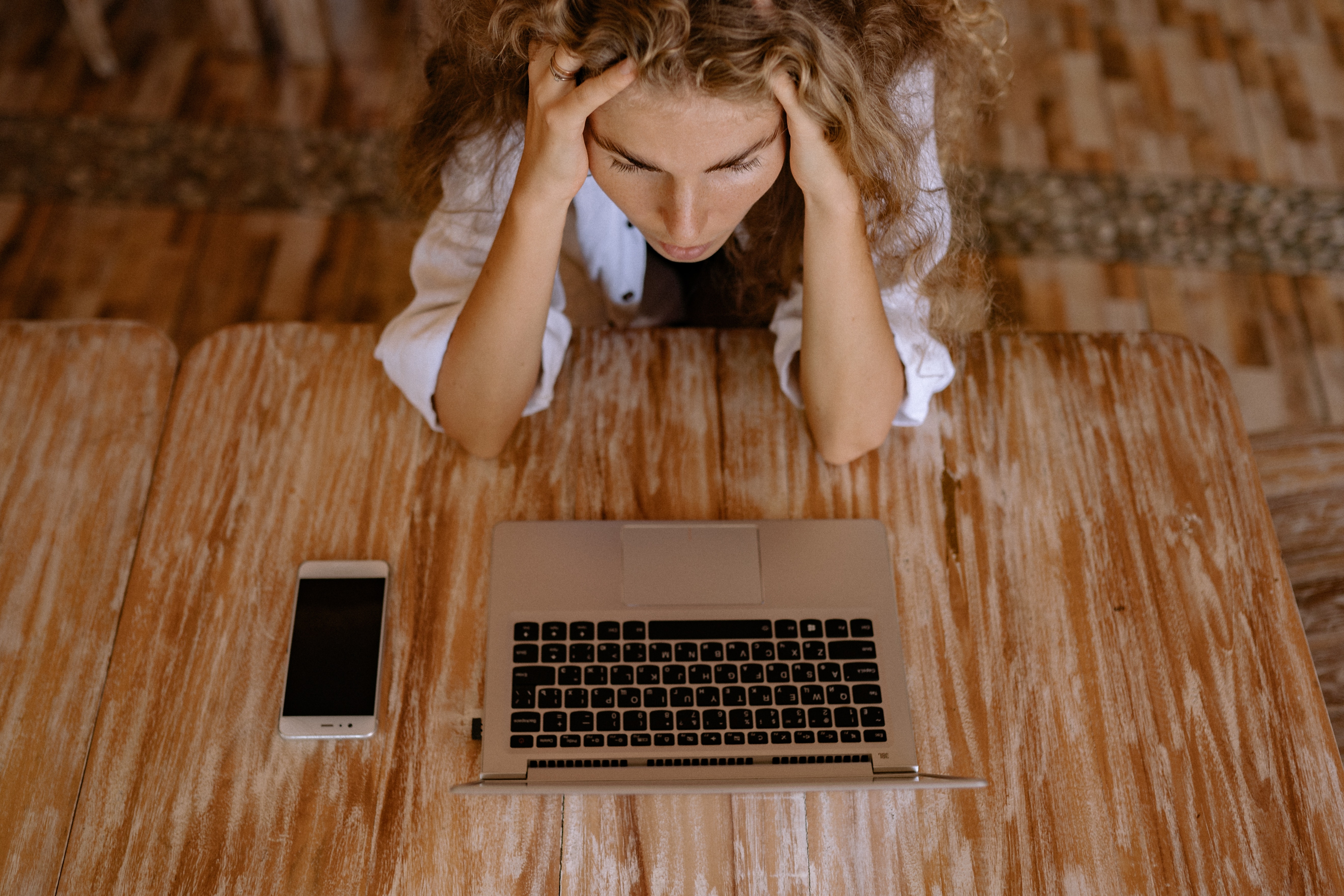 Woman looking upset in front of laptop