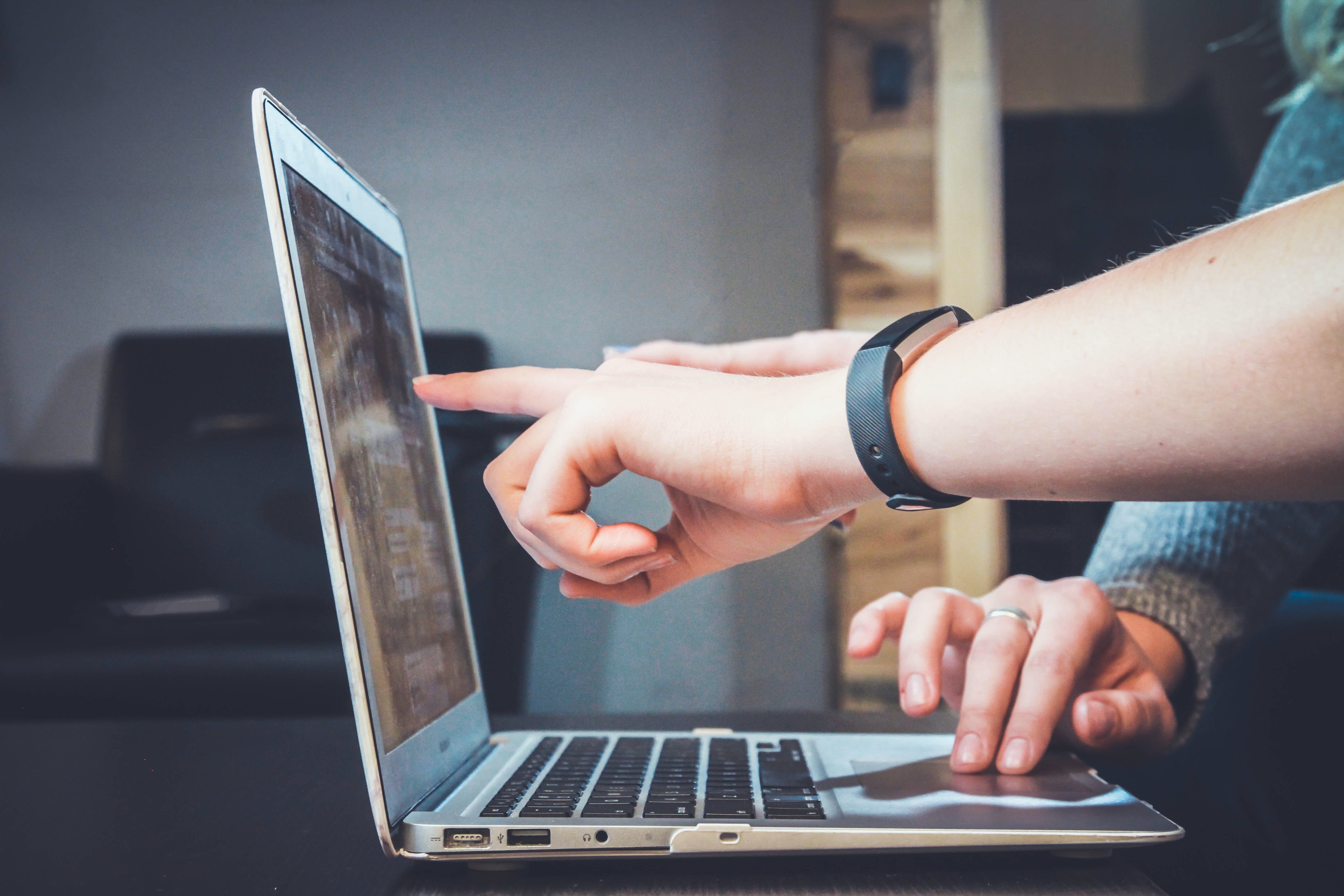 Computer users pointing at screen