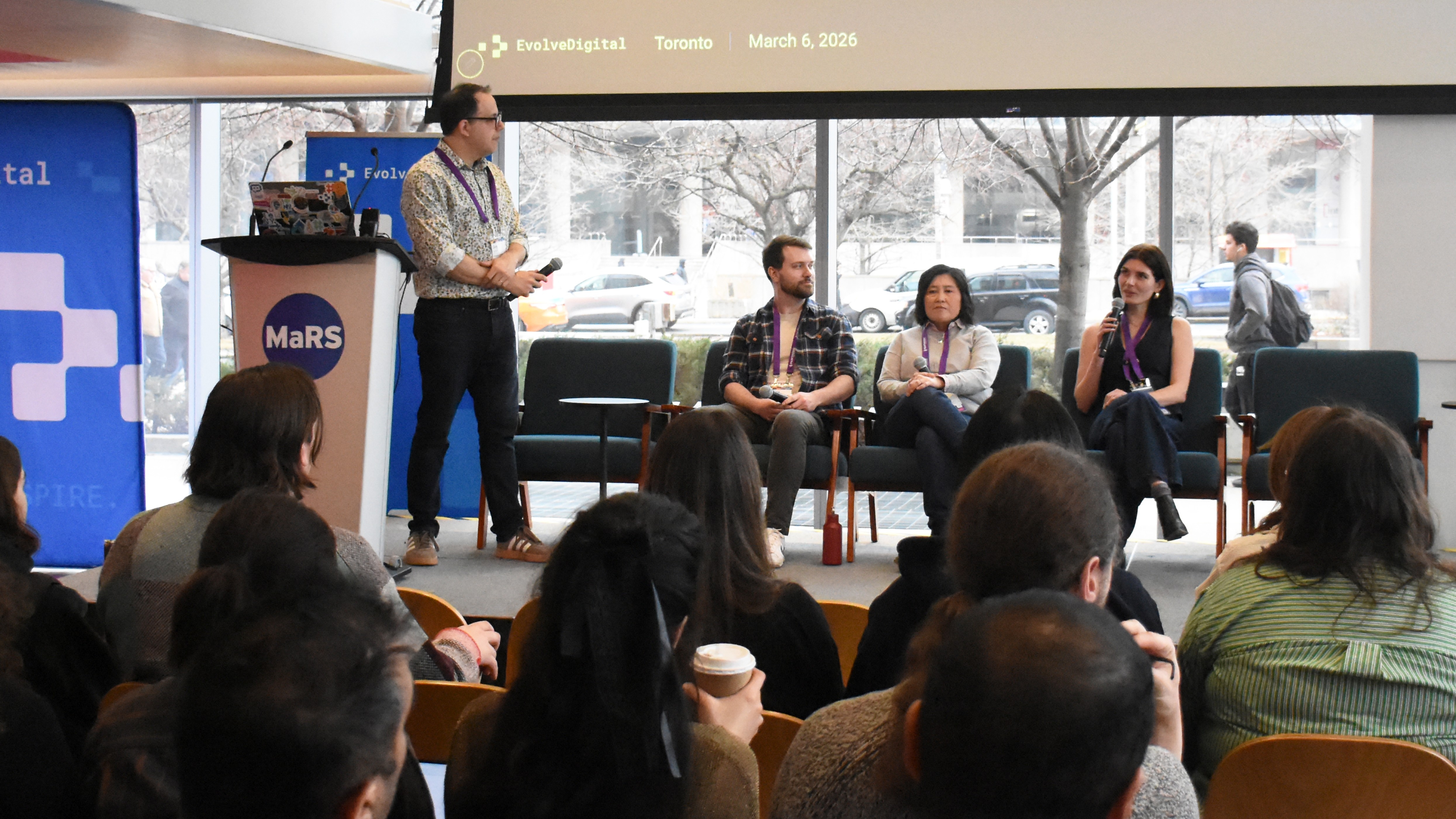 Four panelists speaking on stage at EvolveDigital Toronto 2026, with the audience in the foreground.