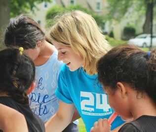 Woman helping young girls with school work