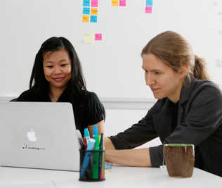 Two people in front of a laptop