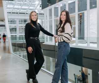 Deux personnes souriantes debout dans un bâtiment de HEC Montréal