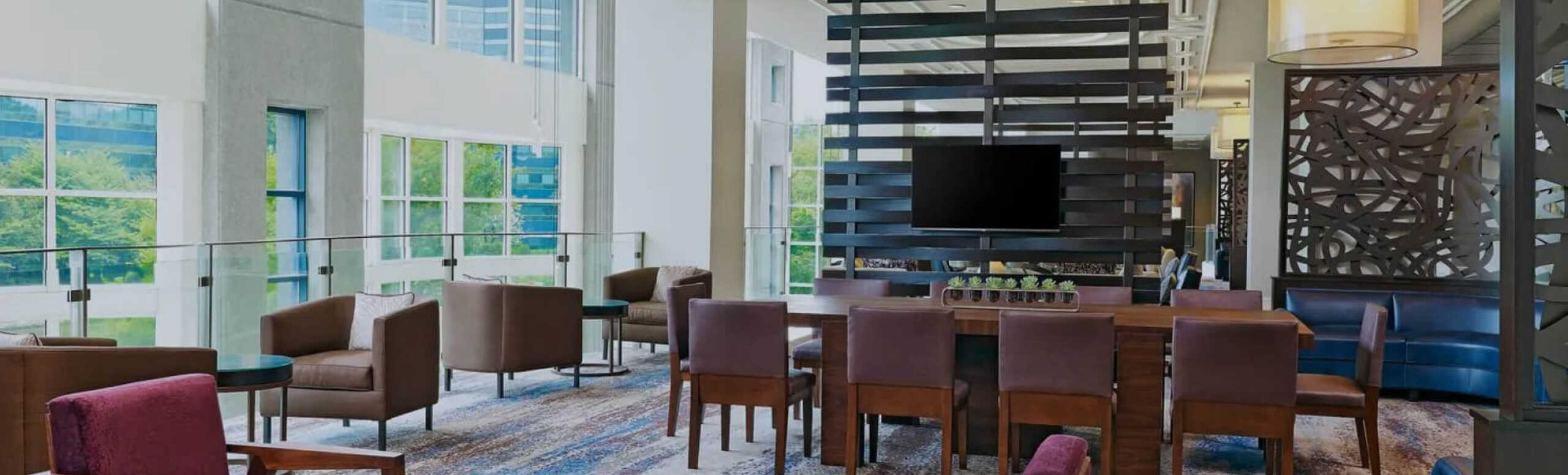 A photo of an empty reception area featuring chairs and tables