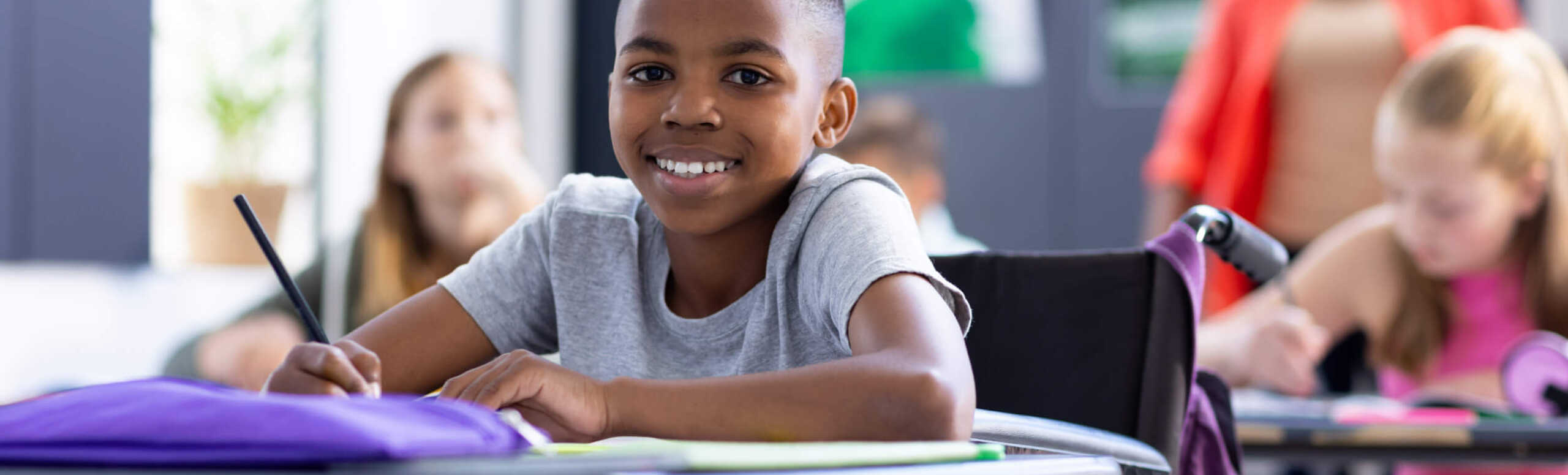 Un enfant est assis au pupitre dans la classe.