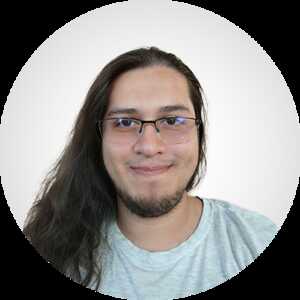 a headshot of Marco, who has long hair and wears glasses