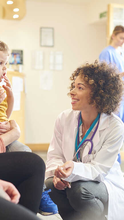 Doctor speaking to a young patient in a waiting room