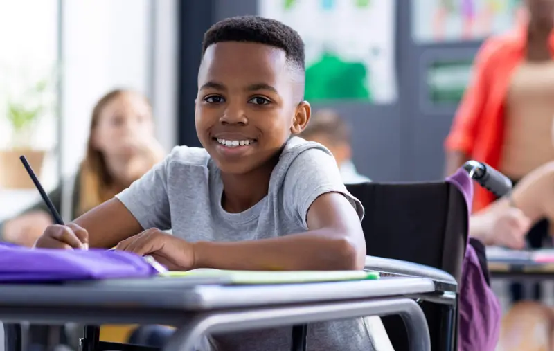 Un enfant est assis au pupitre dans la classe.