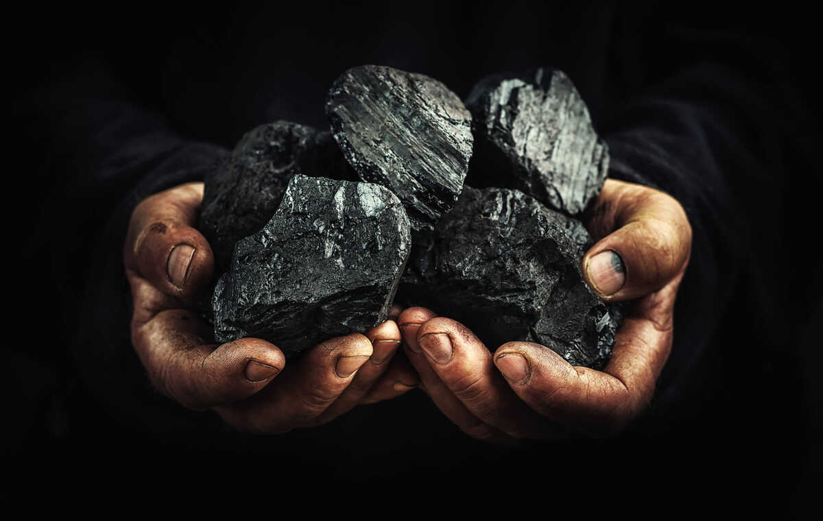 An image with two hands holding a large piece of mineral