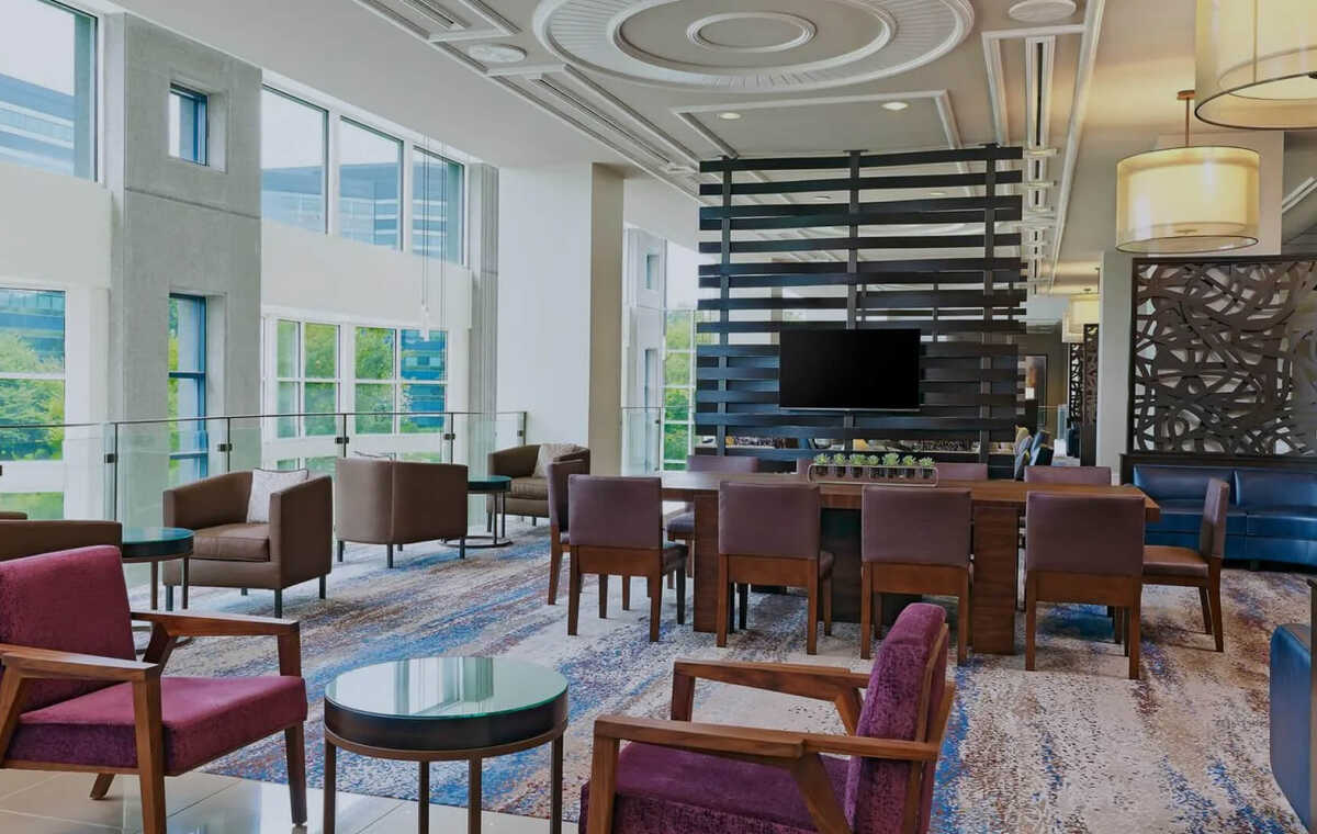 A photo of an empty reception area featuring chairs and tables