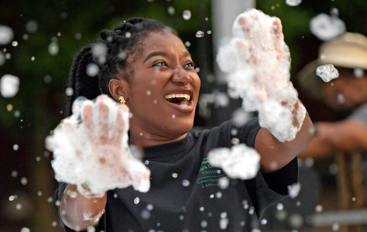 A GGC student is laughing and covered in bubbles