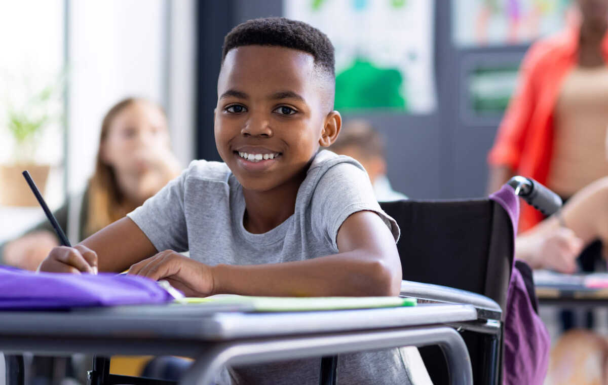 Un enfant est assis au pupitre dans la classe.