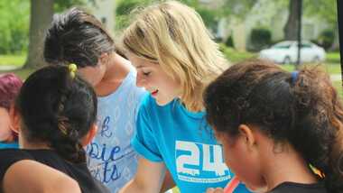 Woman helping young girls with school work